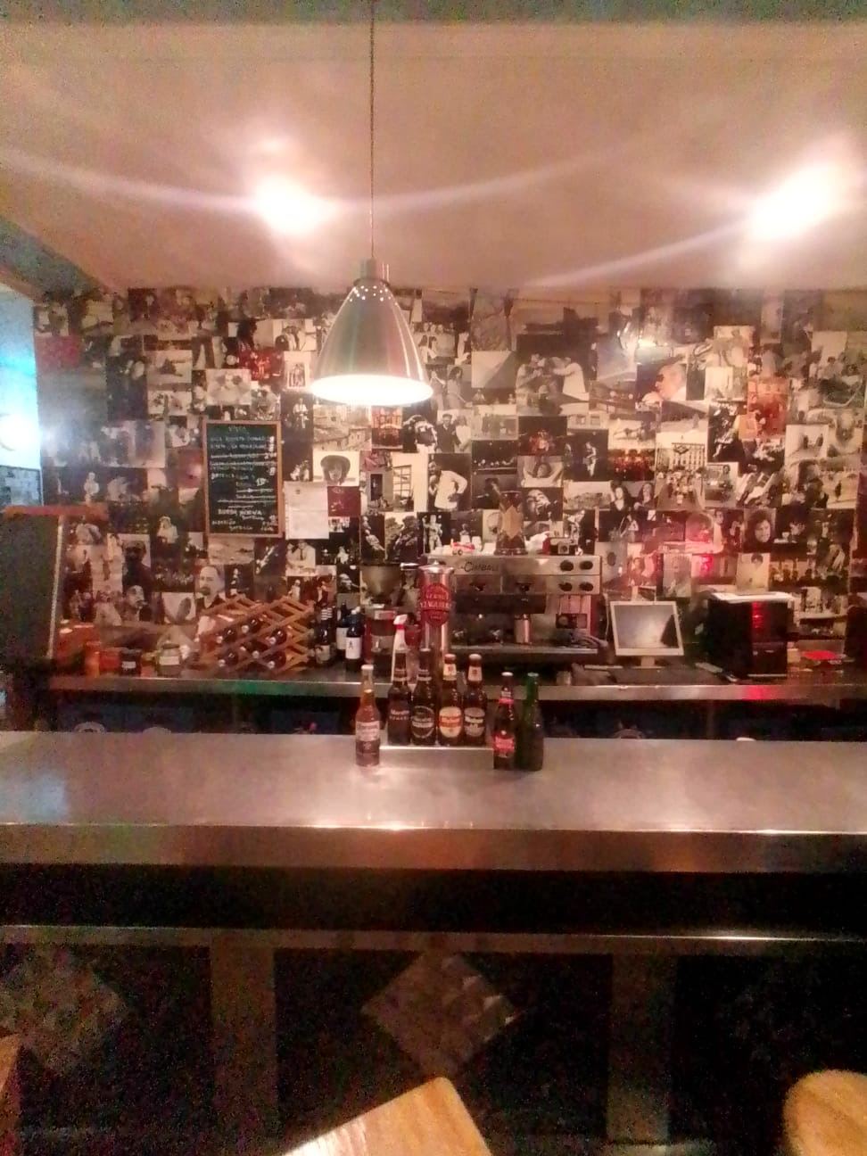 Barra con botellas y pared de fotografías