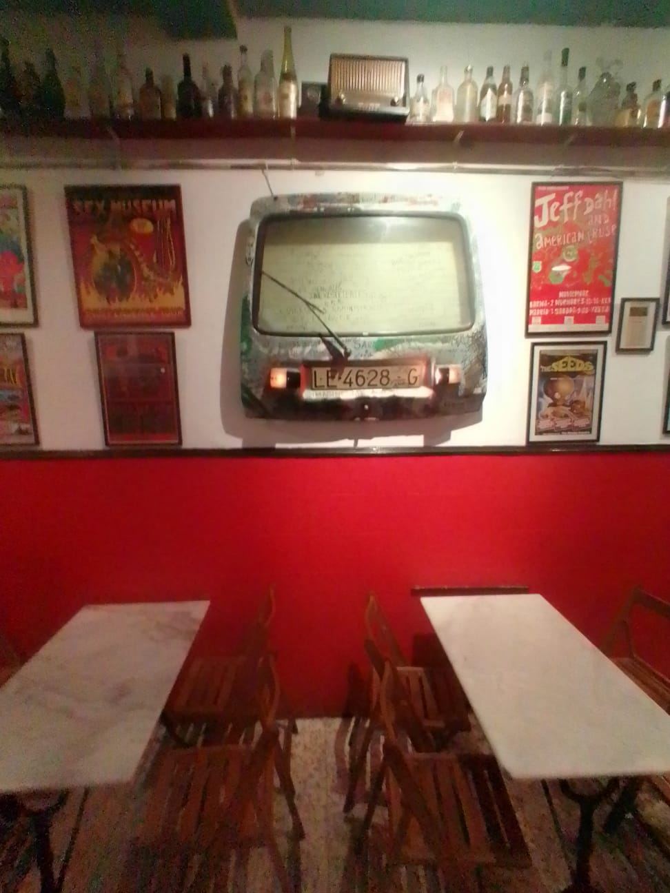 Pared roja con pieza de arte y mesas de mármol