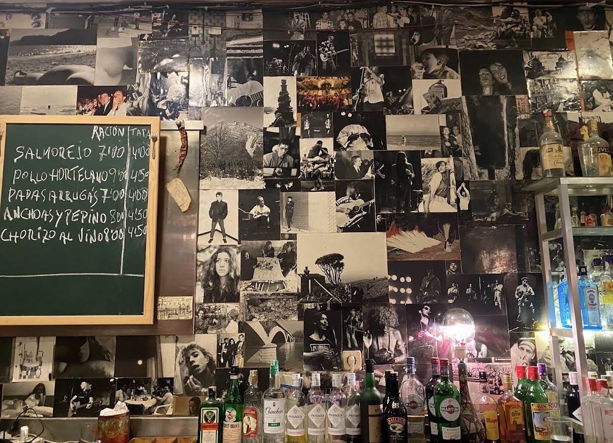 Pared cubierta de fotografías en blanco y negro dentro de Tapas y Fotos