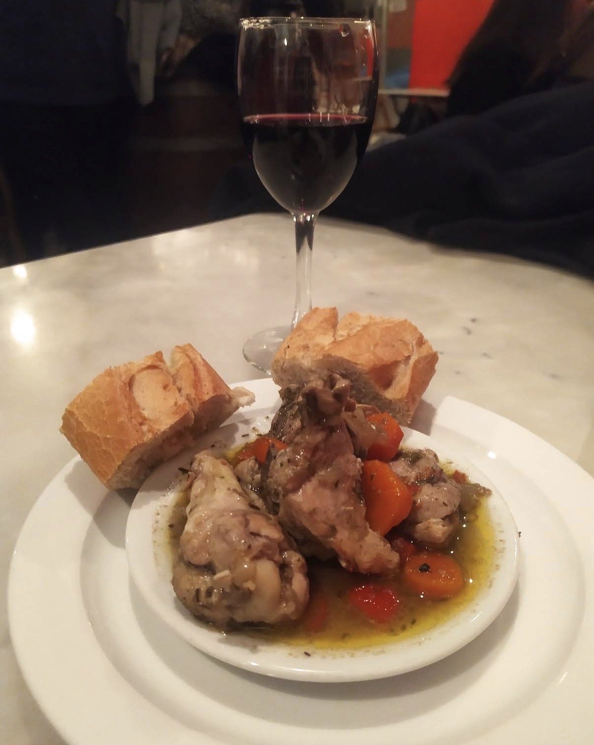 Pollo Hortelano servido con pan y copa de vino tinto